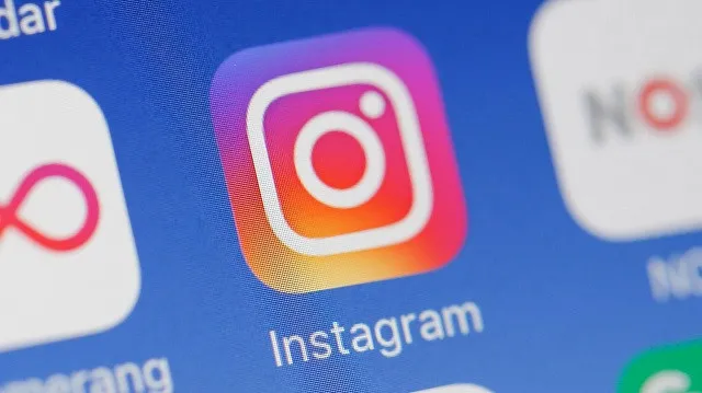 Close-up of the Instagram app icon on a smartphone screen, showcasing the vibrant Instagram camera logo and the word"Instagram" beneath it.