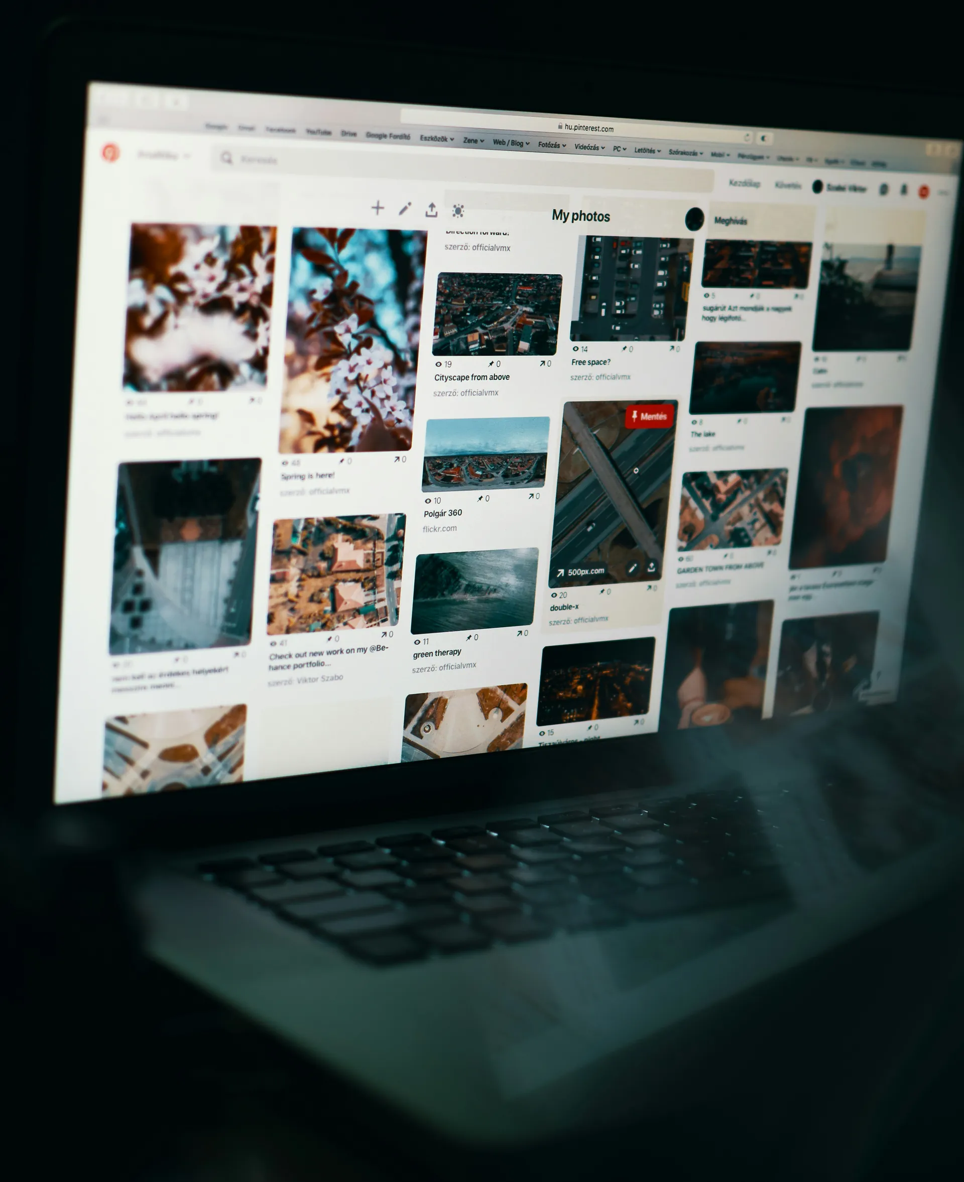A laptop screen displays a Pinterest page showing a collection of photo pins under the"My photos" board.